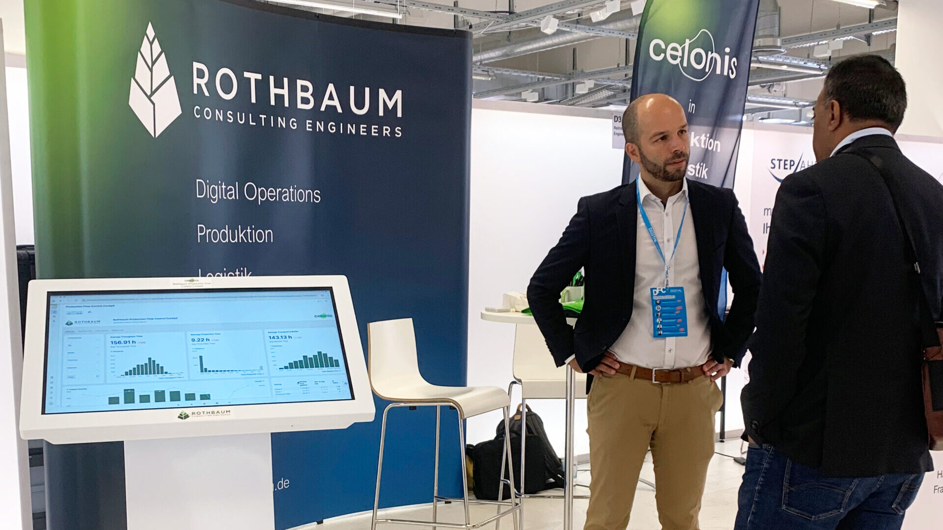 Dr. Clemens Wolf vor dem Messestand beim DIGITAL FUTUREcongress in München am 28. September vor der Verleihung des BVMID IT-Business Awards 2023. Im Vordergrund ist ein Touch Display mit interaktiver Process-Mining-Demo zu sehen.