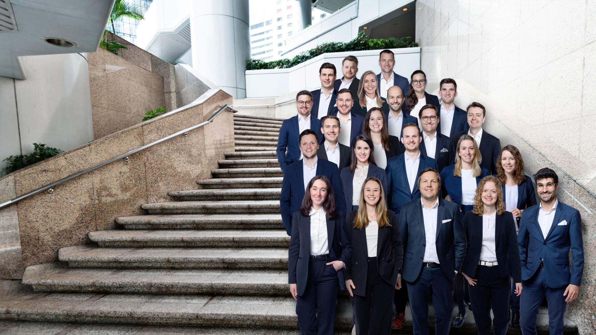 Header zu Karriere bei Rothbaum mit Gruppenbild des Rothbaum Teams auf einer Treppe