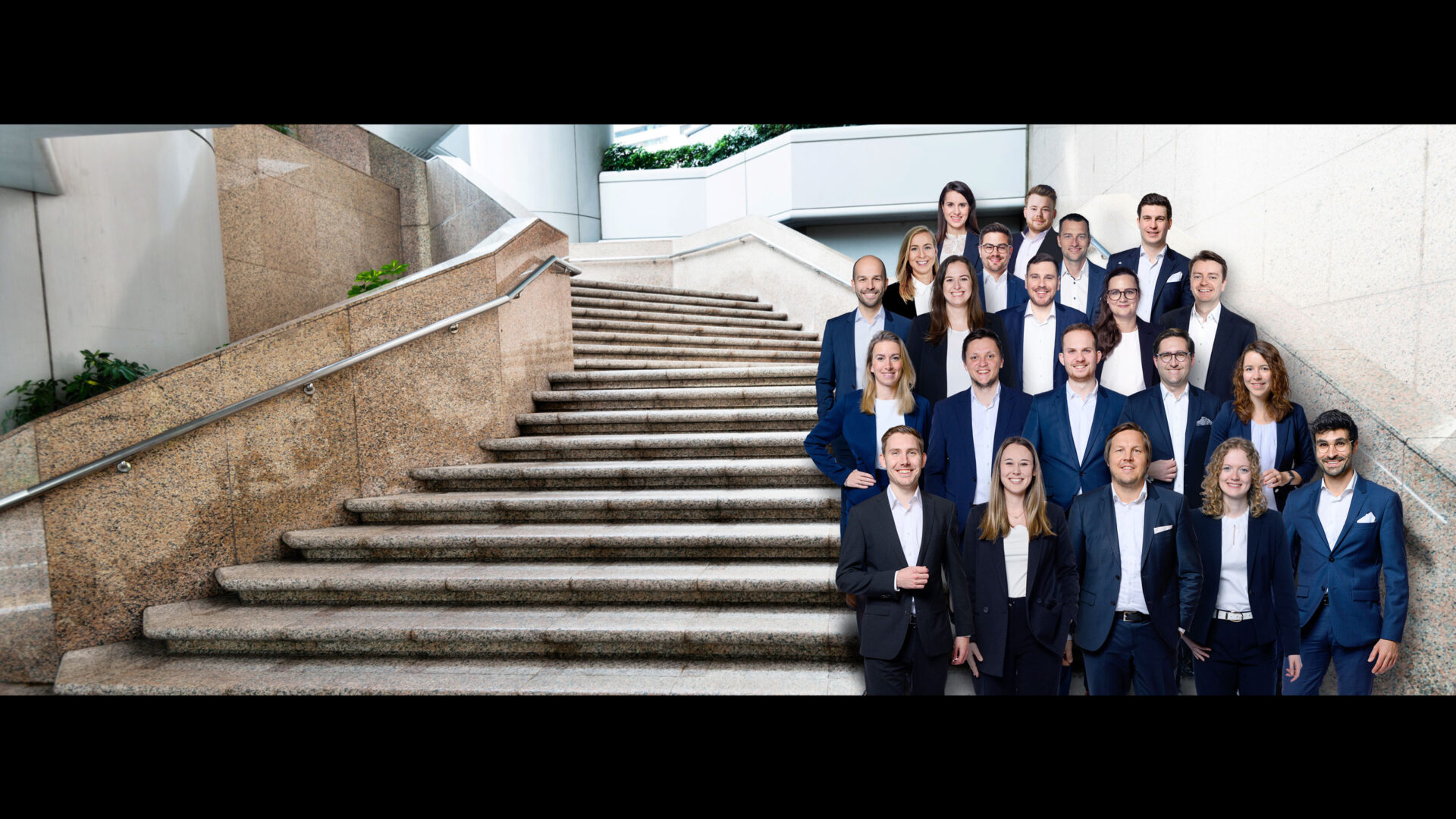 Header zu Karriere bei Rothbaum mit Gruppenbild des Rothbaum Teams auf einer Treppe