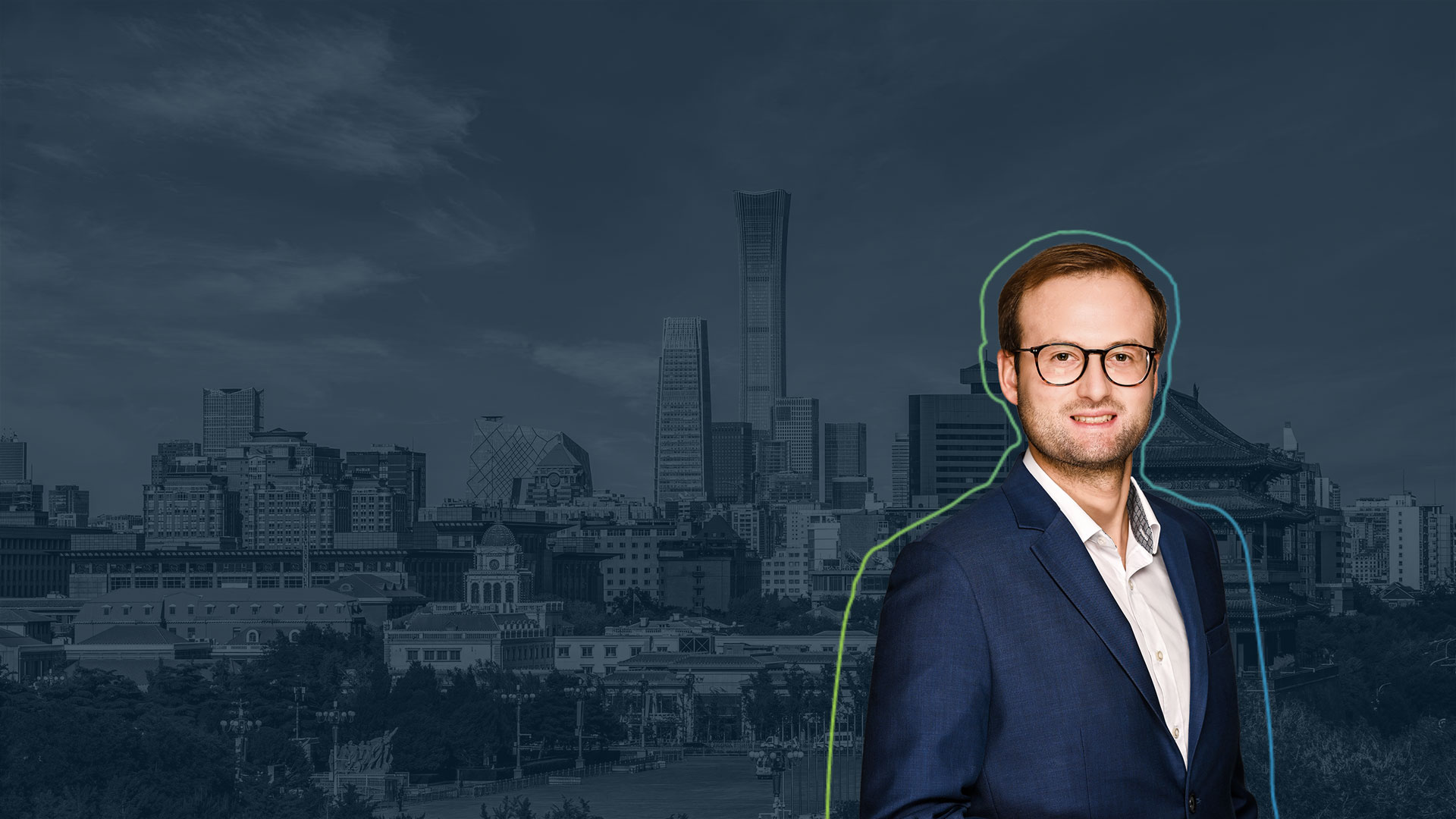 Mann in dunklem Anzug und weißem Hemd vor einer Stadtlandschaft mit Hochhäusern